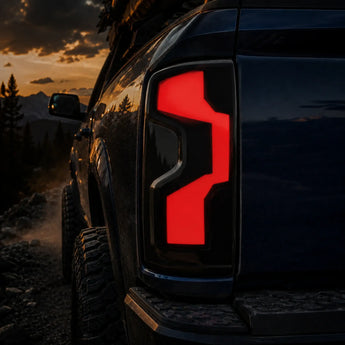 Close-up of smoked LED tail lights on a 2019-2023 Chevrolet Silverado 1500 off-road at sunset