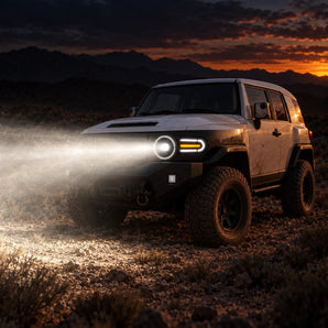 2007-2014 Toyota FJ Cruiser with PRISMBEAM LED headlights projecting a strong light beam in the desert at dusk