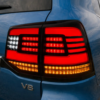 Illuminated PRISMBEAM LED tail light centered in a close-up view on a blue Toyota Land Cruiser.