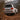 White Toyota Land Cruiser with illuminated LED tail lights climbing a steep dirt trail behind foreground branches.
